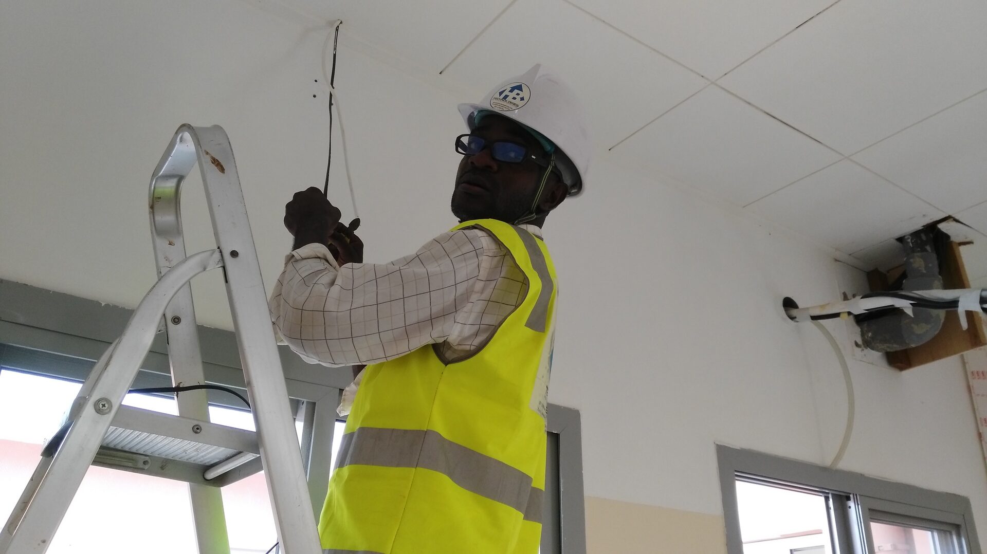 Technicien installant un équipement en hauteur