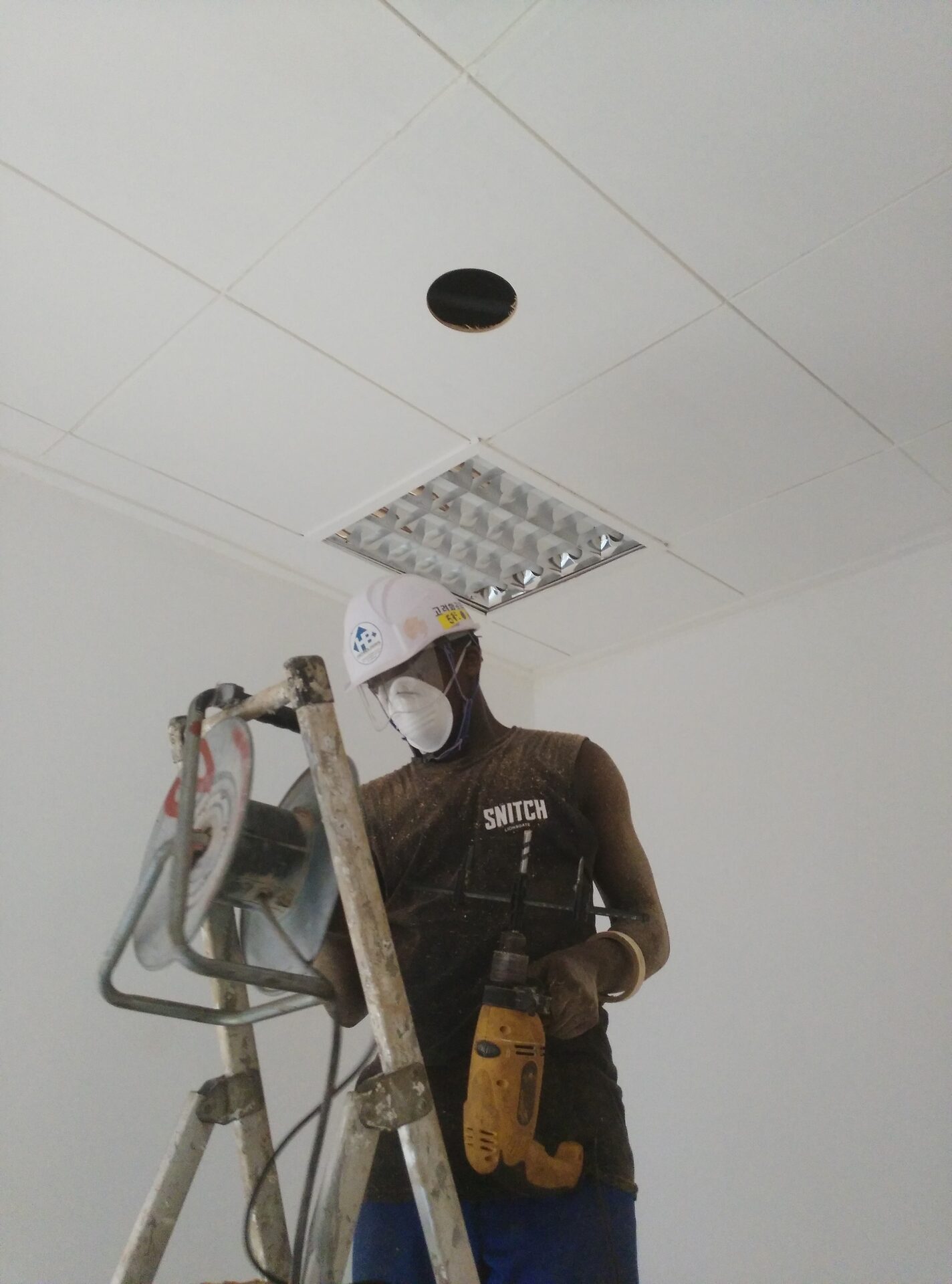 Support IT : technicien effectuant des mesures en faux plafond